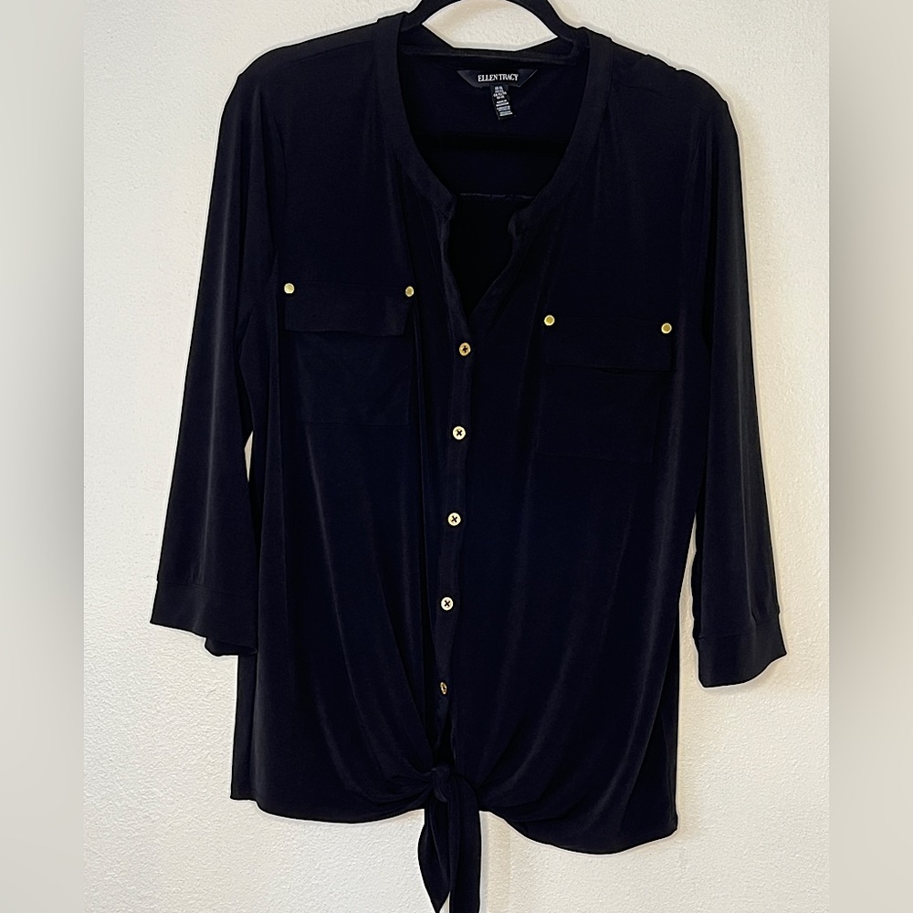 Black blouse with gold button detail has stretch